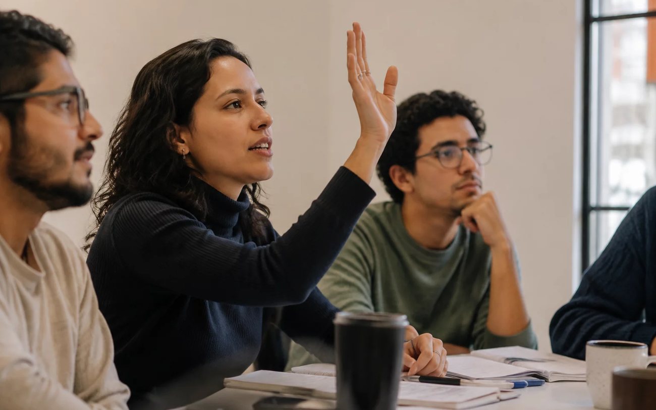 Duas pessoas organizam uma rodada de debate com cadernos abertos e canetas marcadoras